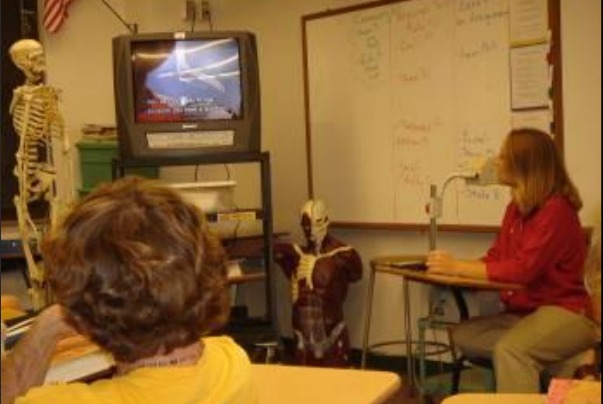 Scharla Becker watching a captioned video with her class