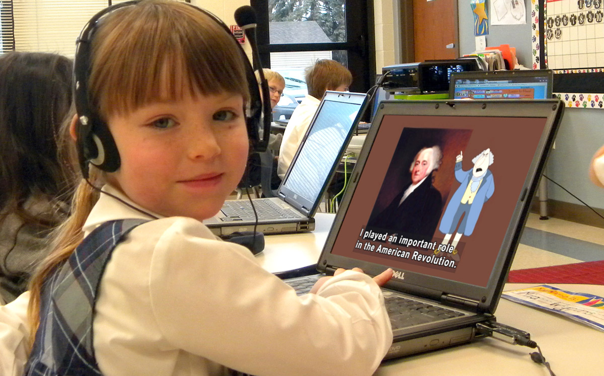 A young girl with sandy hair uses a laptop showing a captioned video in her classroom.